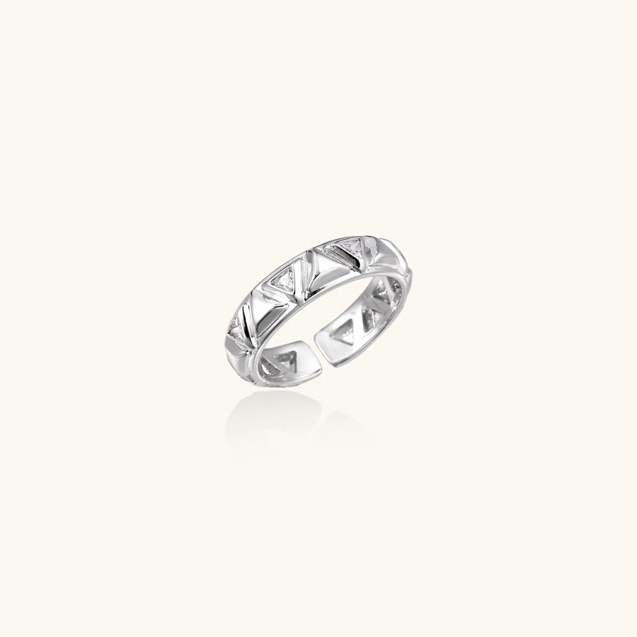 White gold adjustable ring with geometric triangle cutouts and zirconia stones on cream background