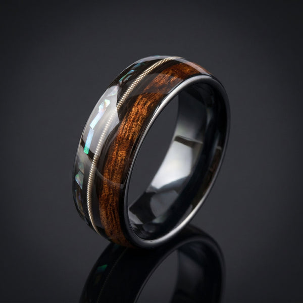 Horizon men's black tungsten ring with whiskey barrel oak, abalone and guitar string inlay – angled view