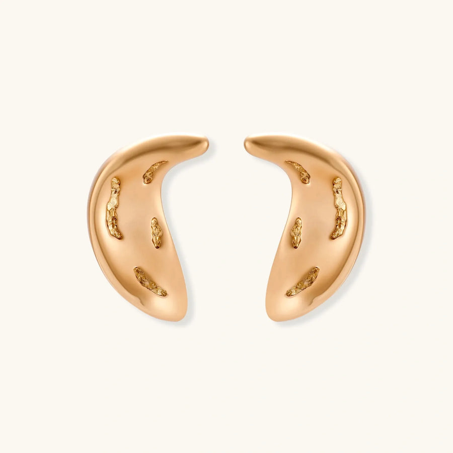 Pair of gold crescent moon-shaped stud earrings with textured surface details on cream background.