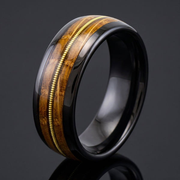 Harmonia men's black tungsten ring with whiskey barrel oak and guitar string inlay – angled view