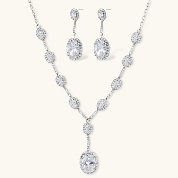 Elegant white gold plated jewelry set with oval cubic zirconia stones in halo settings, featuring Y-necklace and drop earrings.