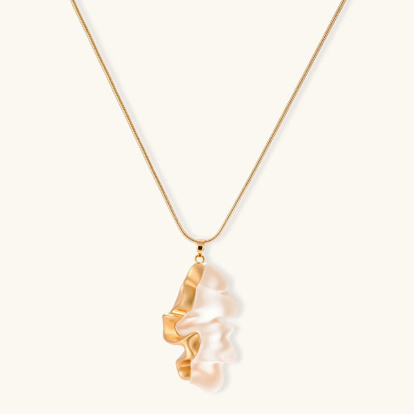 Close-up of a sculptural necklace with flowing wave pendant made from eco-zinc alloy on adjustable chain