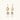 Gold sunburst charm earrings with baroque pearl drops on French hooks against cream background