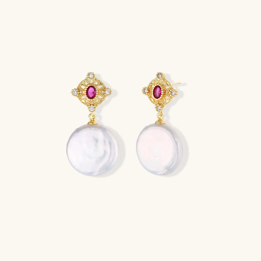 Gold baroque pearl earrings with pink gemstone studs and ornate detailing on cream background.