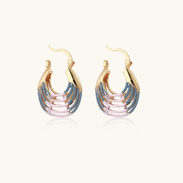 Gold hoop earrings with gradient blue-to-pink enamel in ribbed fan design on beige background