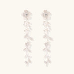 Long sterling silver drop earrings with delicate floral vine design and crystal accents on white background