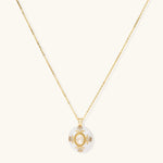 Gold-plated necklace with circular white enamel pendant featuring central zirconia stone and ornate decorative details