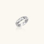 White gold adjustable ring with geometric triangle cutouts and zirconia stones on cream background