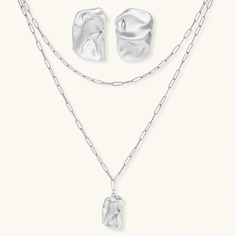 Modern textured hoop earrings and layered chain necklace with liquid metal pendant in silver and gold finishes.