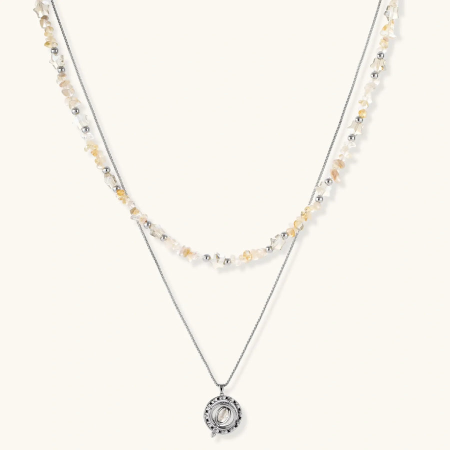 Complete jewelry set featuring citrine stone chips, silver beads, and cosmic circle pendants on cream background.