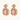 Ornate gold-plated jewelry set with rose pink zirconia center stones and crystal accents on cream background.