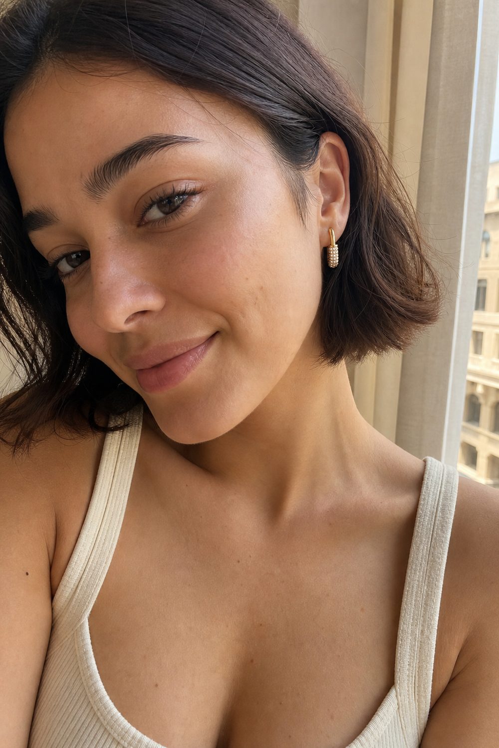 Customer wearing Golden Glow Huggie Hoops